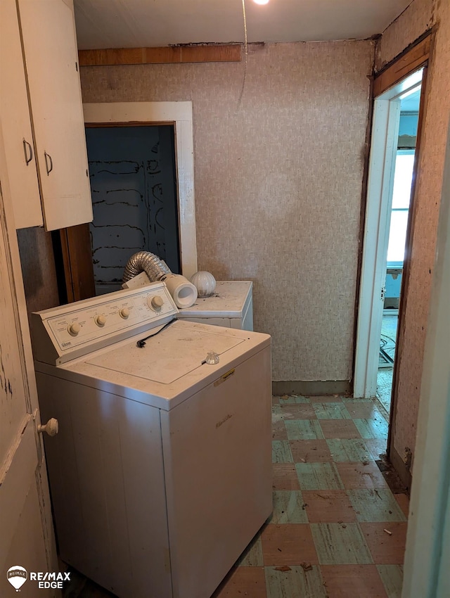 laundry room with separate washer and dryer and cabinets