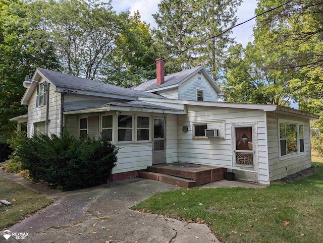 view of front of home with a front lawn and cooling unit