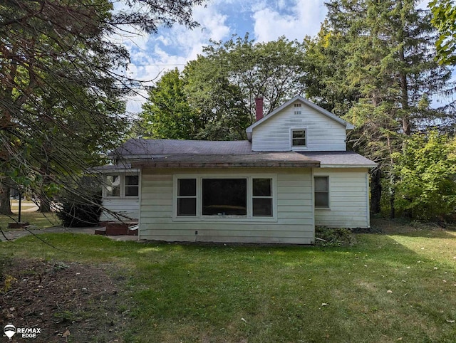 rear view of property with a lawn