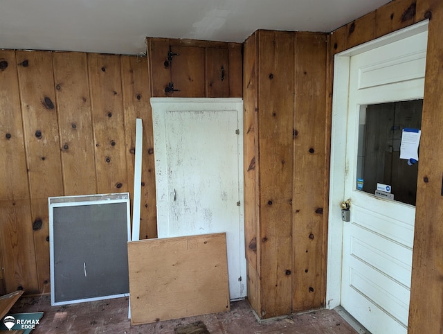 unfurnished room featuring wood walls