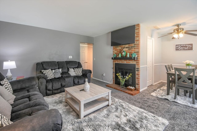 carpeted living room featuring ceiling fan and a brick fireplace