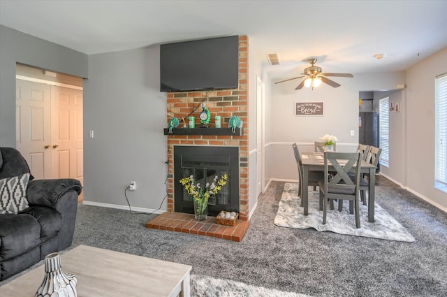 living room with ceiling fan, carpet floors, and a fireplace