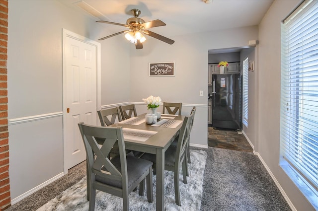 carpeted dining area with ceiling fan