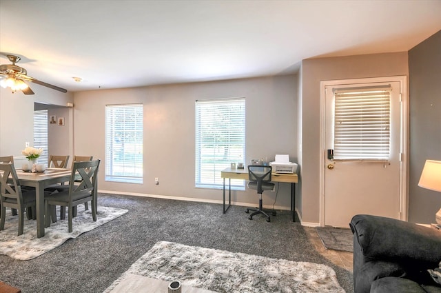 dining area featuring dark colored carpet and ceiling fan