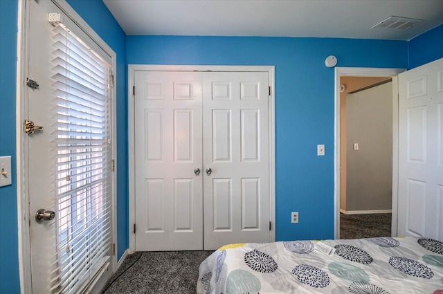 bedroom with a closet and dark colored carpet