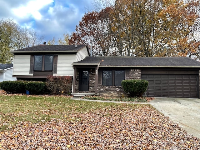 tri-level home featuring a garage and a front lawn