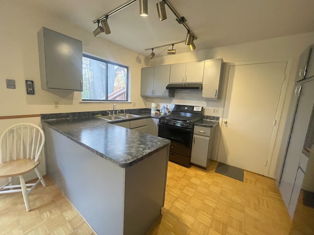 kitchen featuring gray cabinetry, black gas stove, kitchen peninsula, and sink