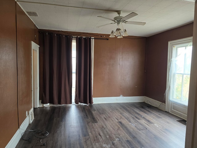 empty room featuring a wealth of natural light, ceiling fan, and hardwood / wood-style flooring