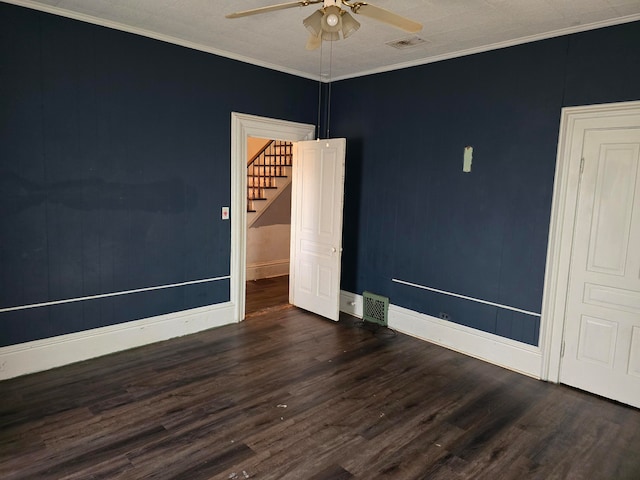 spare room featuring ceiling fan, dark wood-type flooring, and ornamental molding