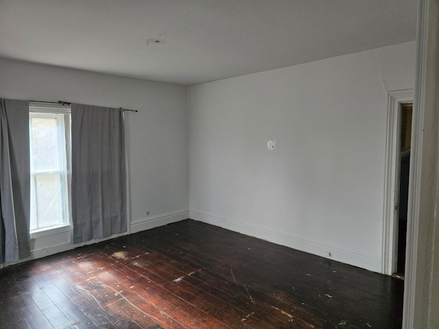 empty room with dark hardwood / wood-style flooring