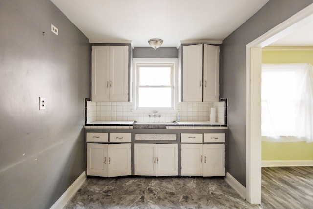 kitchen with backsplash, tile countertops, and white cabinets