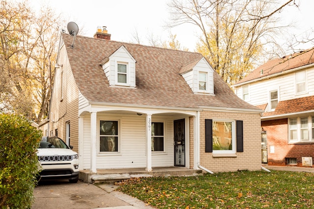 new england style home with a porch and a front yard