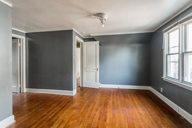 empty room with hardwood / wood-style flooring, ceiling fan, and lofted ceiling