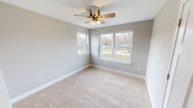 empty room featuring ceiling fan and light colored carpet