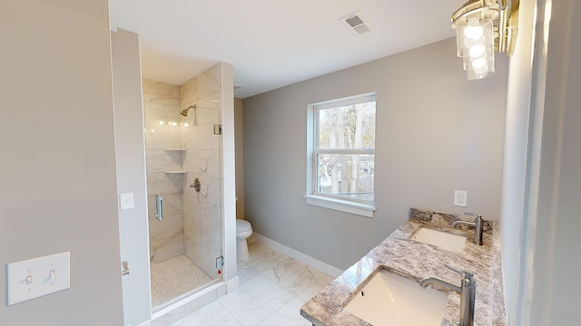 bathroom with vanity, toilet, and a shower with door