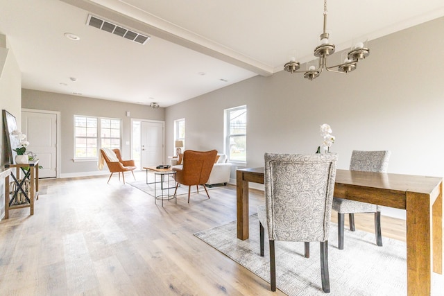 dining area featuring light hardwood / wood-style floors and a notable chandelier