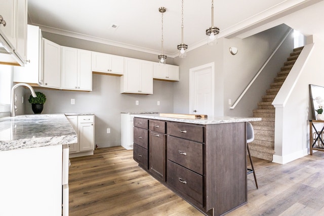 kitchen featuring white cabinets, hardwood / wood-style floors, and a kitchen island