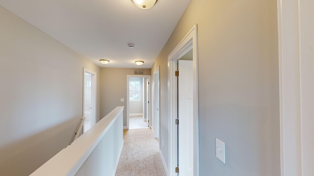 hallway featuring light colored carpet