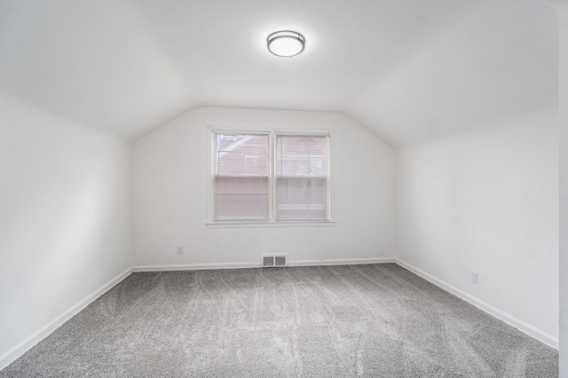 bonus room with carpet floors, visible vents, vaulted ceiling, and baseboards