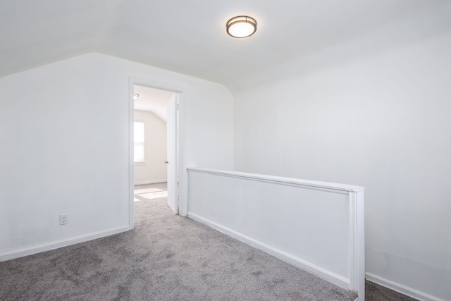 interior space featuring lofted ceiling, carpet, and baseboards