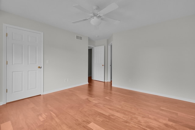 empty room with ceiling fan and light hardwood / wood-style flooring