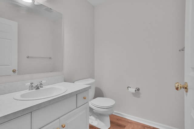 bathroom with hardwood / wood-style floors, vanity, and toilet