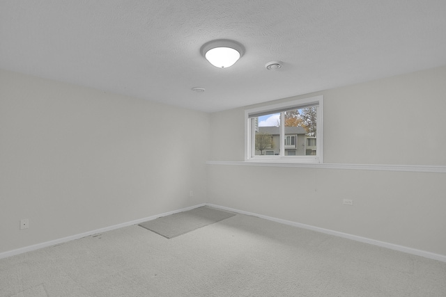 empty room with carpet floors and a textured ceiling