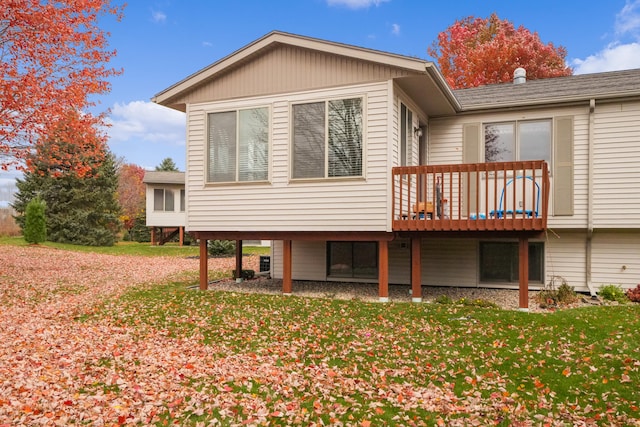 back of property featuring a lawn and a deck