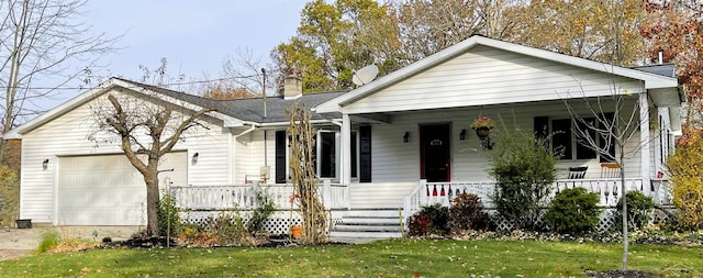 bungalow-style home with covered porch, a front yard, and a garage