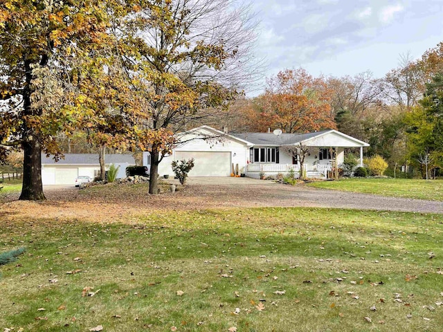 view of front of home with a garage, covered porch, and a front lawn