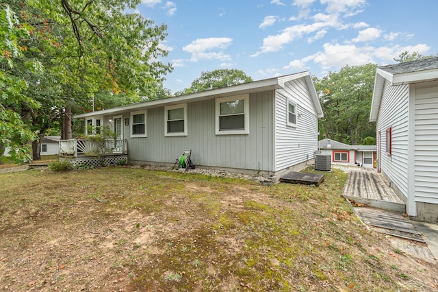 rear view of property featuring a lawn and a wooden deck