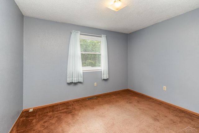 carpeted empty room featuring a textured ceiling