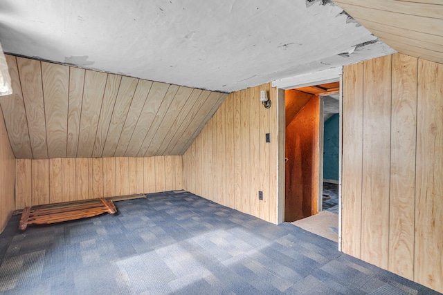 additional living space featuring wooden walls, lofted ceiling, and carpet floors