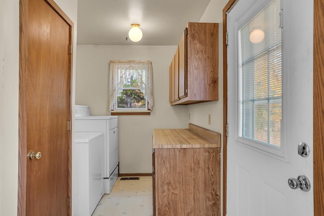 laundry area featuring cabinet space, independent washer and dryer, baseboards, and a healthy amount of sunlight