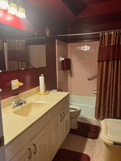 full bath with toilet, vanity, shower / bath combination with curtain, and tile patterned floors