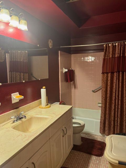 bathroom with shower / tub combo with curtain, vanity, toilet, and tile patterned floors