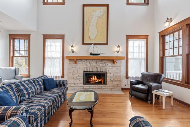 5722 Dunham Path, Stevensville, MI 49127 - living area featuring wood finished floors, a fireplace, a high ceiling, and plenty of natural light
