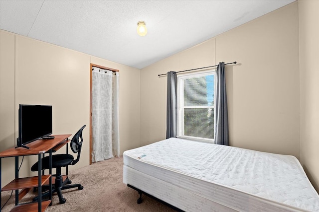 carpeted bedroom featuring a textured ceiling and vaulted ceiling