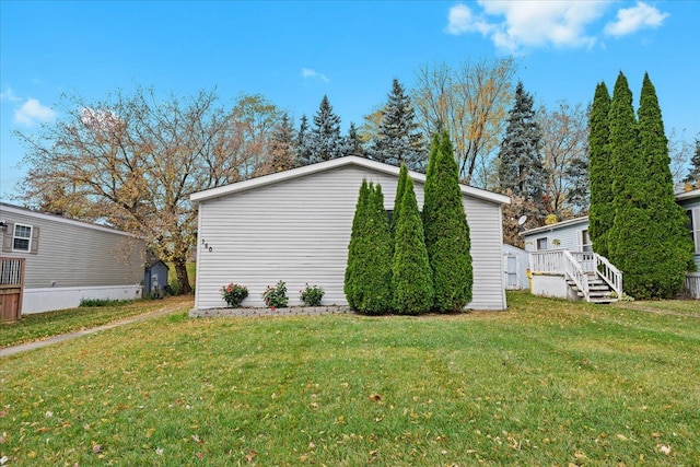 view of home's exterior with a wooden deck and a lawn