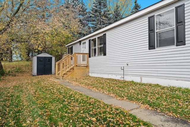 view of home's exterior with a lawn and a storage shed