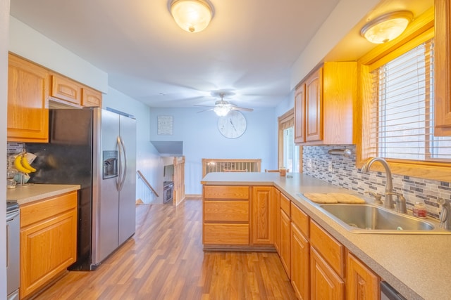 kitchen featuring decorative backsplash, kitchen peninsula, stainless steel appliances, sink, and hardwood / wood-style floors