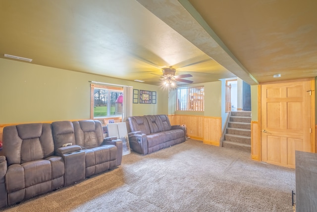 living room with carpet, wooden walls, and ceiling fan