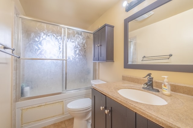 full bathroom with tile patterned floors, vanity, toilet, and bath / shower combo with glass door