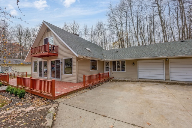 view of front of home featuring a balcony, a garage, and a wooden deck