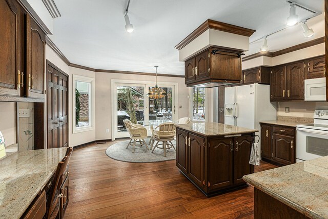 kitchen with rail lighting, dark brown cabinets, white appliances, dark wood-type flooring, and decorative light fixtures