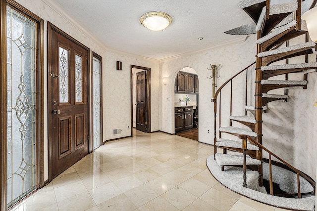 entrance foyer featuring crown molding and a textured ceiling