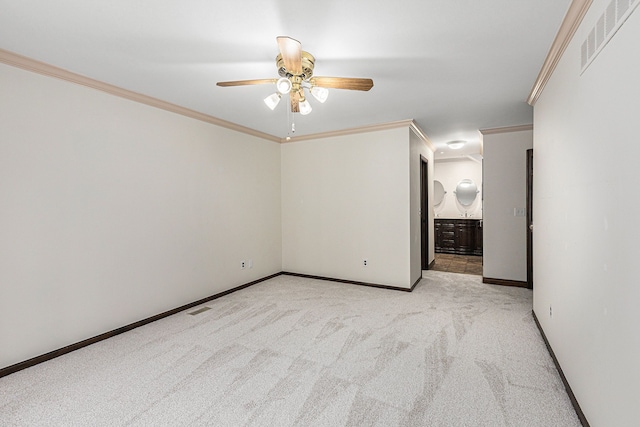 carpeted spare room with ceiling fan and crown molding