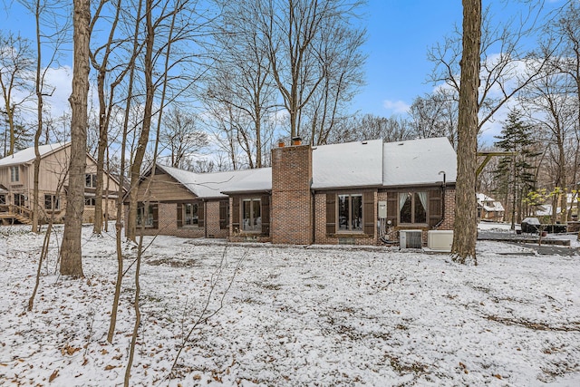 snow covered rear of property with central air condition unit