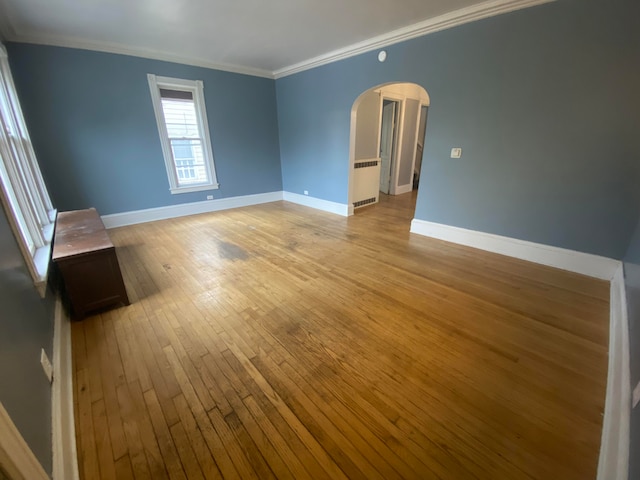 unfurnished room with light wood-type flooring and crown molding