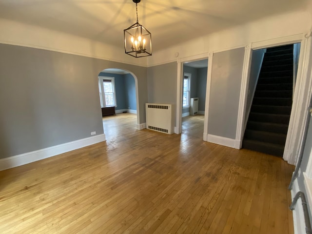 unfurnished dining area featuring hardwood / wood-style flooring and radiator